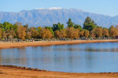 Altın sonbahar ağaçları Perris Gölü 'nün sakin suları ve kumlu kıyıları, uzak karla kaplı dağları, açık hava aktiviteleri için mükemmel..
