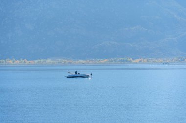 Perris Gölü 'nün sakin, pırıl pırıl mavi sularında, uzak dağları ve renkli ağaç çizgileriyle sakin bir gün geçirmeyi seven bir insan..