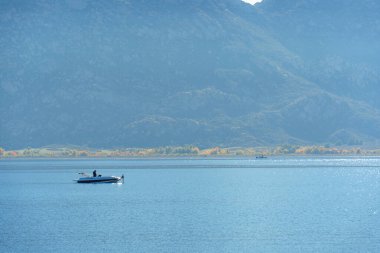 Perris Gölü 'nün sakin sularını dağları ve parlak bir gökyüzünün altında sonbahar ağaçlarını olan küçük bir teknede severler..