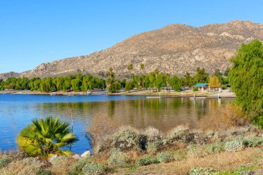 Perris Gölü Eyalet Dinlenme Alanı 'nın sakin suları, engebeli dağlar ve bereketli kıyı şeridi yeşillikleriyle çevrili gökyüzünü yansıtıyor..