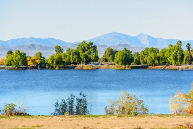 Perris Gölü 'nün sakin mavi suları yemyeşil ve altın ağaçlar uzak kıyılarda, görkemli dağlarla destekleniyor..