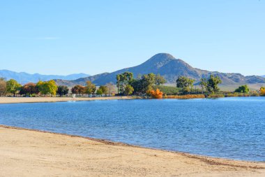 Perris Gölü Eyalet Dinlenme Alanı 'nın suları kumlu kıyılar ve uzak tepelerle çevrili mevsimsel değişimi yansıtıyor..
