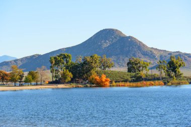 Perris Gölü 'nün sakin suları çarpıcı bir sonbahar manzarasını yansıtır. Rocky dağları kumlu bir kıyı şeridiyle kesişiyor. Titrek düşen ağaçlarla benekli..