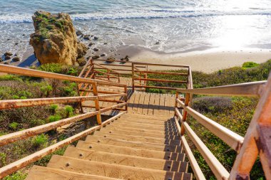 Kırsal merdivenler El Matador Eyalet Sahili 'nin resimli kumlu sahiline çıkar. Okyanus dalgaları görkemli bir kayanın yanında karayı nazikçe öper..