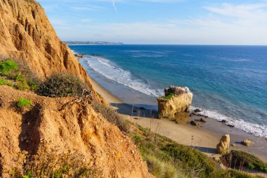 Dramatik kumtaşı kayalıkları ve eşsiz deniz yığını oluşumları, El Matador Eyalet Sahili 'nin resimli kumlu sahilini çerçeveler, altın güneş ışığıyla yıkanır..