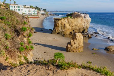 Malibu 'daki El Matador Eyalet Sahili' nde altın kumlar üzerinde etkileyici kumtaşı yığınları sergileniyor. Parlak mavi okyanus dalgaları yavaşça kıyıya vuruyor..