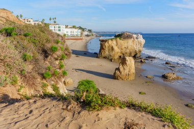 Görkemli deniz yığınları ve yıpranmış kaya oluşumları, El Matador State Beach 'in güneşli kumlu sahillerini, Pasifik Okyanusu' nun yumuşak dalgaları ve yeşil kayalıklarıyla noktaladı..