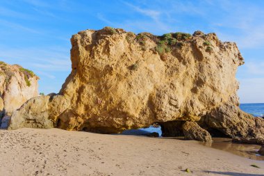 Etkileyici kaya oluşumları ve doğal kemerler El Matador Eyalet Sahili 'nin el değmemiş altın kumlarını yontuyor. Parlak California gökyüzünün altında pırıl pırıl..