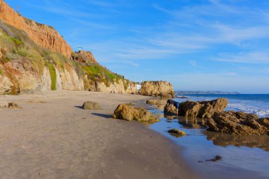 Engebeli uçurumlar ve ikonik deniz yığınları Malibu 'daki El Matador Eyalet Sahili' nin el değmemiş kumlu alanını berrak mavi gökyüzünün altında çevreledi..