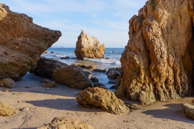 Güneşli El Matador Eyalet Sahili, sakin okyanus dalgalarıyla kumlu sahil şeridi boyunca deniz yığınları ve engebeli kaya oluşumlarına ev sahipliği yapıyor..