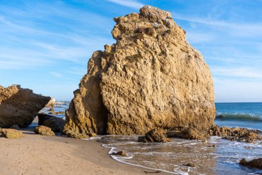 Görkemli deniz yığını El Matador Eyalet Sahili 'ne hakim. Engebeli yüzey altın güneş ışığıyla yıkanmış. Yumuşak dalgalar tabanını okşuyor..