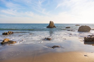 Dramatik deniz yığınları ve doğal kaya oluşumları Malibu 'daki El Matador Eyalet Sahili' nde gün batımında hafif dalgalardan ortaya çıkar. Seyahat ve doğa temaları arka plan.