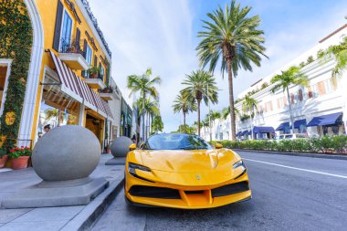 Beverly Hills, California - 21 Ocak 2026: Sarı Ferrari SF90 Stradale, Beverly Hills, Kaliforniya 'da bulunan sembolik Rodeo Drive' da park halinde, palmiye ağaçları ve lüks butiklerle çevrili.