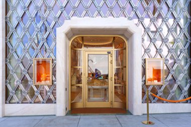 Beverly Hills, California - 21 Ocak 2026: Rodeo Drive 'daki Bvlgari mağazası altın kemer yolu, cam kapılar, karmaşık elmas desenli pencereler ve aydınlatılmış vitrinler.