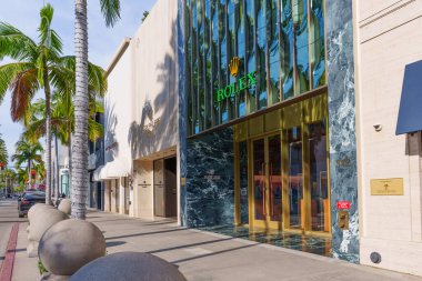 Beverly Hills, California - 21 Ocak 2026: Patek Philippe 'in yanındaki Rolex butiğinin lüks yeşil mermer cephesini gösteren Rodeo Drive kaldırımı boyunca bakın.