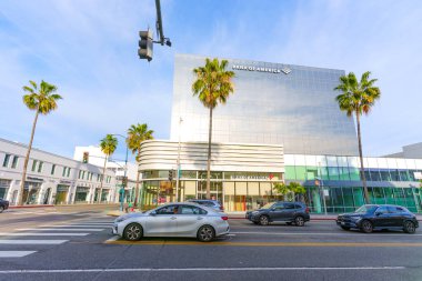 Beverly Hills, California - 21 Ocak 2026: Modern, cam panelli Bank of America finans merkezi Beverly Hills 'de güneşli bir cadde köşesinde trafik vardı..