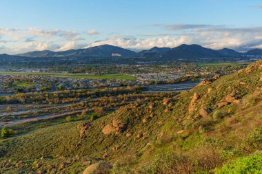 Güney Kaliforniya 'daki Rubidoux Dağı' nın kayalık yamaçlarından Riverside Vadisi 'nin ve etrafındaki dağların manzaralı manzarası..