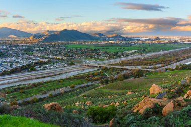 Santa Ana Nehri 'nin ve Riverside' ın yüksek manzarası Rubidoux Dağı 'ndan ve Memorial Park' tan görülen dramatik bir günbatımı gökyüzünün altında Jurupa Hills ile yayılıyor..