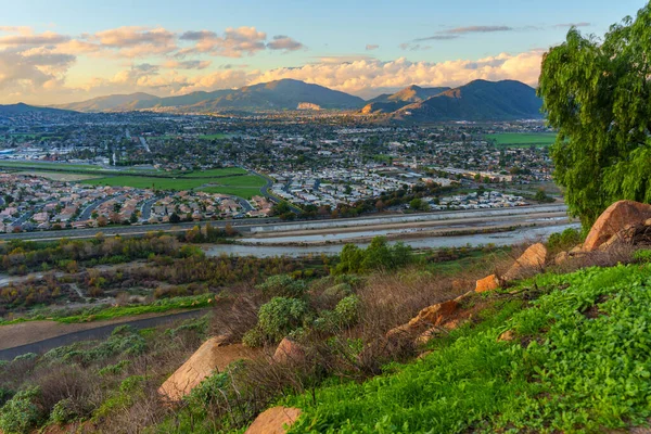 Rubidoux Dağı 'ndan Riverside California' nın panoramik manzarasında Santa Ana Nehri ve altın gün batımı ışığı altında uzak dağlar yer alıyor..