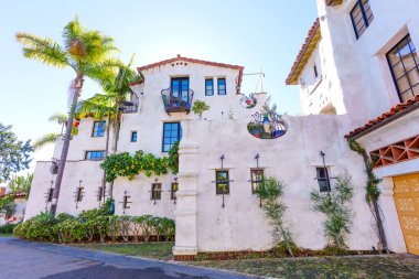Güzel Santa Barbara evi, beyaz sıva, kırmızı kiremit çatılar, yemyeşil, palmiye ağaçları, süslü demirden balkonlar ve pencereler..