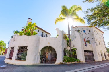 Çarpıcı Santa Barbara binası dairesel pencereli eklektik mimari, renkli mozaik aksanlar, eşsiz bir giriş ve parlak gökyüzüne karşı bir palmiye ağacı içeriyor..