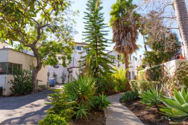 Serene bahçe yolu verimli subtropikal bitki ve ağaçların arasından esiyor, Santa Barbara 'daki beyaz sıva İspanyol Koloni Uyanış binalarına çıkıyor..