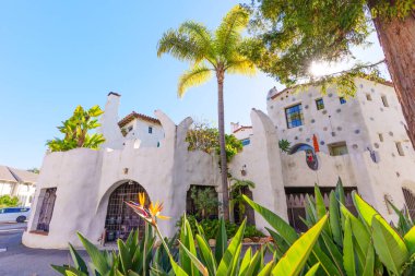 Santa Barbara, California - 29 Aralık 2025: Akdeniz tarzı bina, beyaz sıva duvarları, dekoratif fayanslar ve Santa Barbara, Kaliforniya 'da parlak mavi bir gökyüzünün altında palmiye ağaçları.