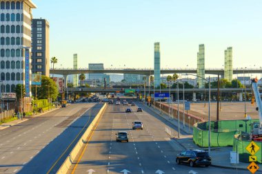 Los Angeles, Kaliforniya - 12 Ocak 2026: Arabalar Los Angeles 'ta mavi gökyüzünün altından şehir mimarisi ile çevrili ikonik LAX direklerine doğru ilerliyor..