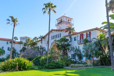 Santa Barbara, Kaliforniya - 29 Aralık 2025: Santa Barbara İlçe Mahkemesi 'nin zarif İspanyol Koloni Diriliş Mimarisi canlı yeşil çimenler ve yükselen palmiye ağaçları arasında duruyor.