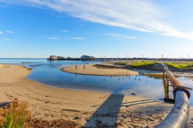 Santa Barbara, California - 29 Aralık 2025: Sahilden görülen Stearns Rıhtımı, Pasifik Okyanusu 'yla kesişen küçük bir nehir yatağının görülebilir bir drenaj borusu ve martıların yer aldığı yer..