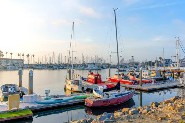 Okyanus Kenarı, Kaliforniya - 17 Aralık 2025: Oceanside 'da canlı marina sahnesi, rıhtım boyunca demirlemiş özel kırmızı gövdeli tekneler ve küçük gemilerden oluşan bir dizi..