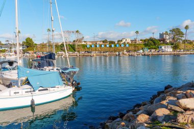 Okyanus Kenarı, Kaliforniya - 28 Aralık 2025: Okyanus Kıyısı Limanı manzaralı, tekneleri barışçıl bir şekilde kenetlenmiş ve 'Okyanus Kıyısı' tabelası yamaçtan ziyaretçileri selamlıyor..