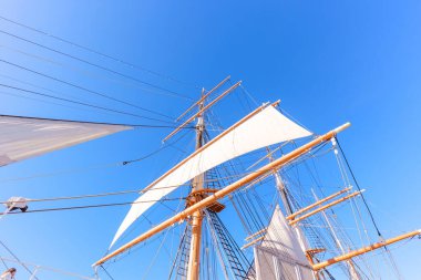 Uzun gemi direkleri ve donanımları, San Diego, California 'da açık mavi gökyüzüne karşı dimdik duruyor. Tarihi deniz mühendisliği ve yelkencilik mirasını gözler önüne seriyor..