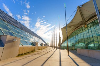 San Diego Kongre Merkezi 'nin ikonik cam ve yelken mimarisi öğleden sonra güneşinde parıldıyor. Parlak çizgiler, uzun gölgeler ve yukarıda parlak mavi bir gökyüzü var..