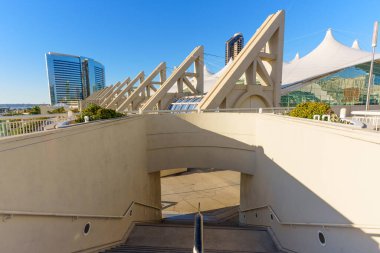 San Diego Kongre Merkezi dış yüzeyinde ikonik beton yapılar ve Güney Kaliforniya 'da açık mavi bir gökyüzünün altında beyaz kumaştan çatılar sergileniyor..