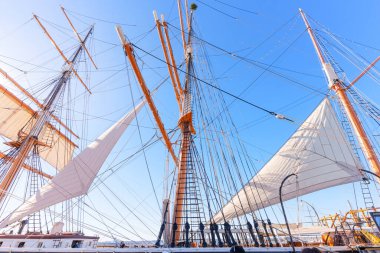 San Diego, California - 30 Aralık 2025: San Diego, Kaliforniya 'daki Denizcilik Müzesi' nde mavi gökyüzüne karşı yükselen vintage yelkenli gemi direkleri, halatlar ve yelkenliler.