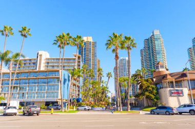 San Diego, California - 30 Aralık 2025 San Diego şehir merkezinde canlı bir cadde, modern mimari, yüksek palmiye ağaçları ve parlak güneşli bir günde şehir hayatının yer aldığı.