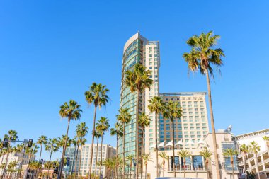 San Diego, California - 30 Aralık 2025: Omni San Diego Oteli ve diğer şehir merkezindeki gökdelenler Kaliforniya, ABD 'de açık mavi bir gökyüzünün altında palmiye ağaçlarının arkasında dikiliyorlar.