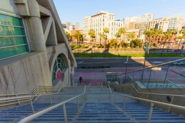 San Diego, California - 30 Aralık 2025: San Diego Kongre Merkezi basamaklarından dinamik bir bakış açısı, şehir sokaklarını, uzak binaları ve canlı şehir merkezindeki palmiye ağaçlarını yakalamak,.