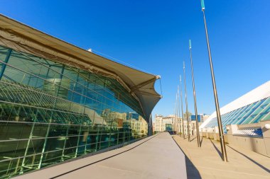 San Diego, California - 30 Aralık 2025 San Diego Kongre Merkezi 'nin gösterişli dış geçidi, açık mavi gökyüzü ve uzak şehir manzarasına karşı modern cam ve çelik tasarımını vurguluyor..