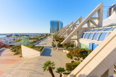 San Diego, California - 30 Aralık 2025: San Diego Kongre Merkezi 'nin genişleyen terası, açık bir gökyüzü altında büyüleyici bir körfez manzarası, hareketli bir marina ve modern şehir mimarisi sunuyor..