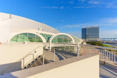 San Diego, California - 30 Aralık 2025: Çağdaş cam kemerler ve San Diego Kongre Merkezi 'nin parlak gökyüzünü yansıtan Hilton otel kulesiyle göze çarpan parlak tasarımı.