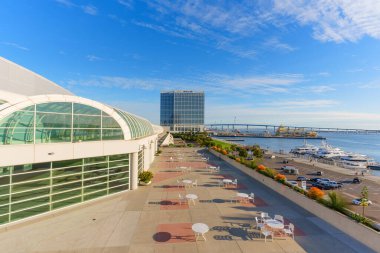 San Diego, California - 30 Aralık 2025: San Diego Kongre Merkezi 'nin beyaz verandalı terasında canlı marina, Hilton Oteli ve Coronado Köprüsü manzarası sunuluyor..