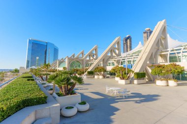 San Diego, California - 30 Aralık 2025: San Diego Kongre Merkezi 'nin geometrik mimarisi, oturma yerleri, şehrin gökdelenleri ve sakin koyları olan yeşil çatı terası ile tamamlanmış..