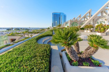 San Diego, Kaliforniya - 30 Aralık 2025: San Diego Kongre Merkezi 'nde lüks ve titiz bir çatı bahçesi, manikürlü çitler, zarif palmiye ağaçları ve şehir manzaralı.