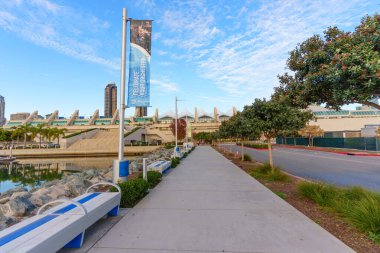 San Diego, California - 30 Aralık 2025: San Diego 'daki rıhtım gezisi modern kongre merkezi ve şehir merkezi ufuk çizgisinin parlak mavi gökyüzü altında ince bulutlar altında görüntüsünü sunuyor..