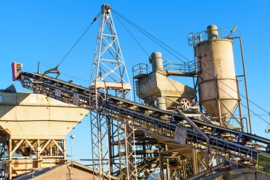 Endüstriyel beton fabrika makineleri, inşaat için Perris, Kaliforniya 'da açık mavi gökyüzüne karşı geniş bir taşıyıcı bant sistemi ve depolama silolarına sahiptir..