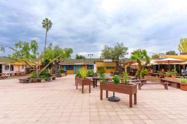 San Diego, California - 30 Aralık 2025: Eski San Diego Şehir Tarihi Parkında renkli binalar, açık hava yemek alanları ve tarihi bir Kaliforniya avlusunda yemyeşil alanlar sergileniyor.