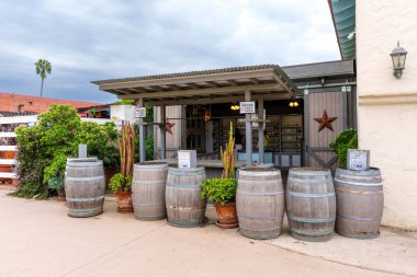 San Diego, California - 30 Aralık 2025: Old Town San Diego 'da kırsal mum ve sabun butiği mağazası bulutlu bir günde, kıvrımlı metal bir çatı altında ahşap fıçılar ve saksı sulandırıcıları barındırır..