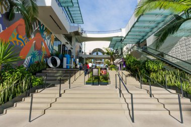 Los Angeles, Kaliforniya - 29 Ocak 2026: Beton merdiven renkli duvar resimleri, palmiye ağaçları ve modern cam mimarinin yer aldığı Ovation Hollywood alışveriş merkezine çıkıyor.